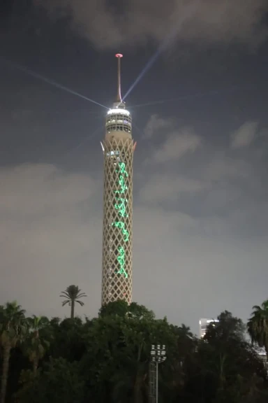 احتفالًا بافتتاح المتحف المصري الكبير.. برج القاهرة يضيء بألوان العلم وعبارات الترحيب