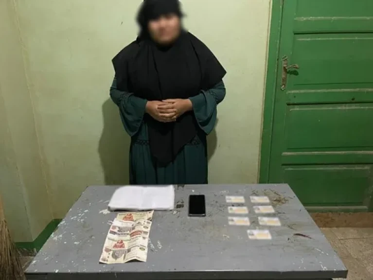 بالصورة .. ضبط إحدى السيدات بمحيط دائرة إنتخابية وبحوزتها بطاقات شخصية ومبلغ مالى تمهيداً لتوزيعهم على المواطنين  للتصويت لصالح أحد المرشحين (بقنا)